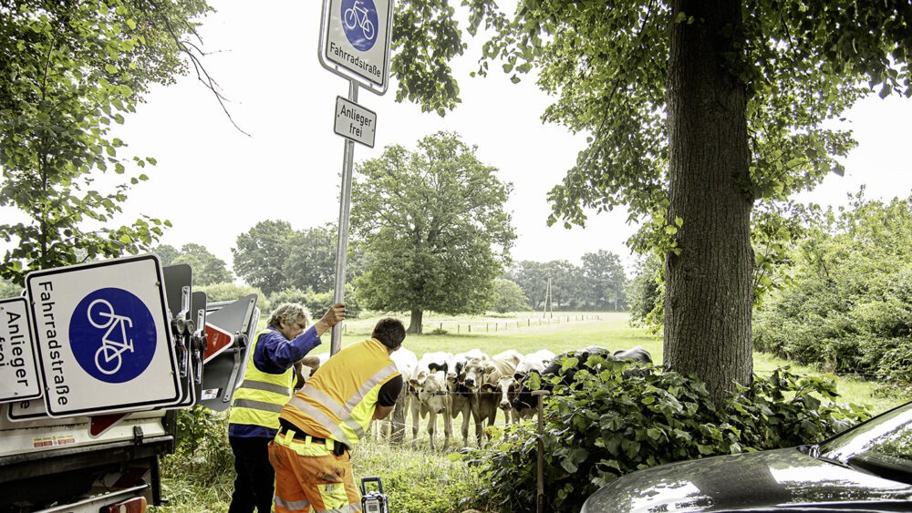Die Bauhofmitarbeiter Uwe Kotnig (links) und Niklas Hetkamp stellen die Schilder für die Fahrradstraße auf (©Frithjof Nowakewitz)