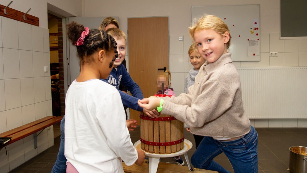 Kinder produzierten Apfelsaft